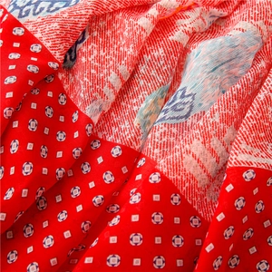 Macro detail of red paisley cotton-linen scarf with geometric patterns and soft texture