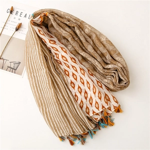 Detailed view of colorful floral pattern and striped cotton-linen scarf with tassels