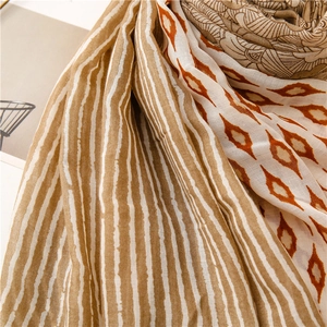Detailed close-up of vintage geometric floral print scarf with warm brown earthy tones