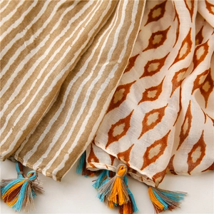 Detail of soft cotton scarf featuring geometric patterns and colorful tassels