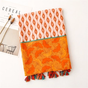 Detail of colorful tassel fringe and geometric floral pattern on cotton linen scarf