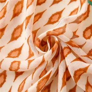 Detailed macro shot of vintage geometric floral print on soft linen-feel scarf fabric