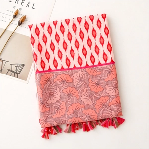 Close-up of geometric floral cotton linen scarf with red fringe tassels and patterns