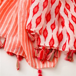 Macro detail of geometric patterns and vibrant fringe tassels on soft bohemian scarf
