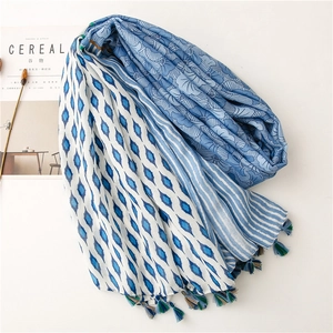 Close-up of geometric floral cotton linen scarf with colorful tassels and soft texture