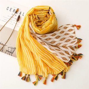 Detail of colorful tassel fringe on long cotton linen scarf with geometric floral print