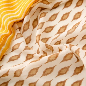 Detail of soft cotton linen shawl with yellow stripes and brown geometric floral patterns