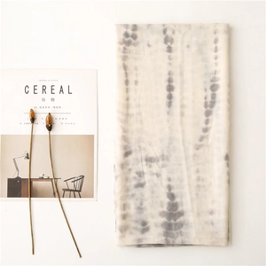 Close-up of lightweight tie-dye scarf with natural cotton linen texture and grey stripes