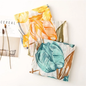 Detail view of colorful floral cotton scarves with tulip patterns on white background