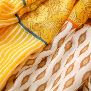 Detailed macro view of geometric floral cotton linen scarf with contrast hem and soft texture