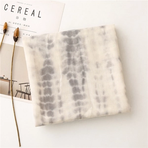 Detail view of a gray tie-dye cotton-linen scarf with delicate vertical dye patterns