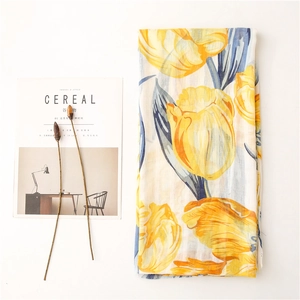 Detail shot of lightweight cotton-linen scarf with yellow tulip floral print on white base