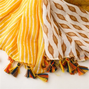 Detail of bohemian geometric shawl featuring vibrant multi-color woven fringe and soft texture