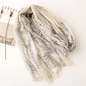 Detailed close-up of soft beige cotton linen shawl with fringe and tie-dye pattern
