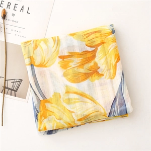 Macro detail of breathable cotton linen scarf with yellow tulip floral print and fringe edges