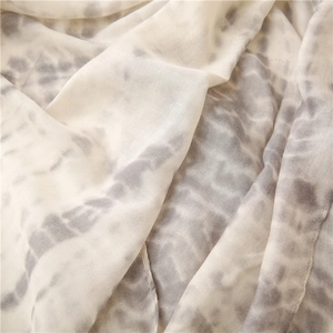 Detail shot of soft tie-dye scarf with fine stitched edges and premium cotton linen texture