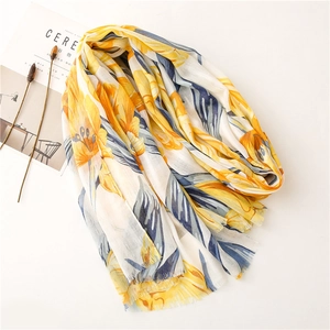 Detail of vibrant floral print scarf with natural frayed edges on a beige background