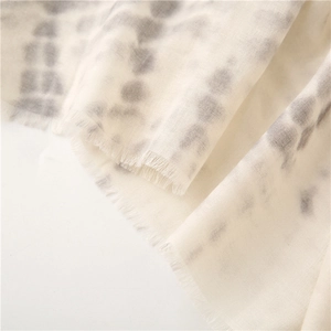 Close-up of soft cotton-linen shawl showing ink-wash texture and frayed tassel edges