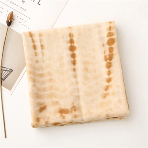 Detail of beige tie-dye scarf with soft linen texture and brown striped pattern