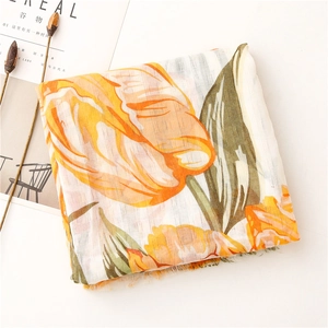 Detailed view of orange tulip floral print on breathable scarf with frayed edges
