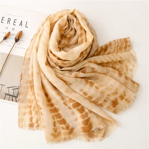 Detail of soft linen-touch scarf with coffee splash pattern and fringe edges