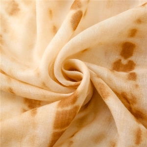 Detailed texture of a soft tortilla print flannel shawl with realistic toasted patterns