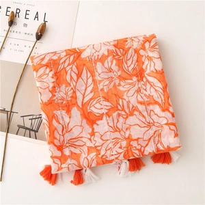 Detailed shot of orange floral scarf with fringe tassels and subtle sequin accents