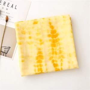 Detail of yellow tie-dye cotton-linen scarf with textured stripe pattern and soft fringe