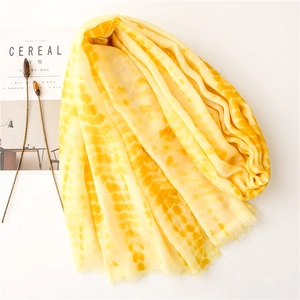 Detailed close-up of yellow gradient tie-dye cotton scarf with fine fringe tassels