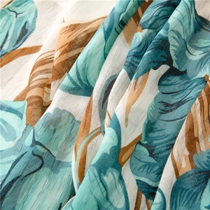 Macro shot of tropical plant print fabric with sheer blue and brown leaf patterns