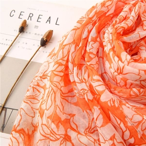 Detail shot of orange floral scarf with sparkling sequins and breathable texture