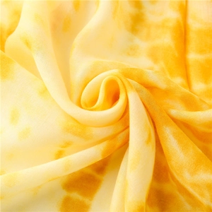 Detailed macro view of yellow and cream tie-dye lightweight cotton linen blend fabric