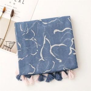 Detail eines blauen Schals mit Marmordruck, abstrakten Linien und farbigen Fransen am Rand