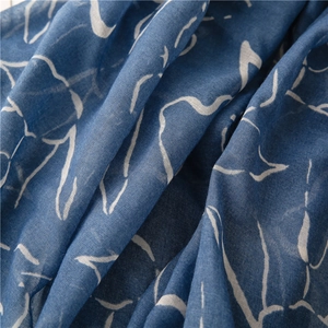 Makro-Detail des blauen Schals mit weißen abstrakten Mustern und Leinen-Textur