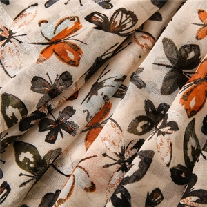 Détail du tissu à imprimé papillon montrant la texture tissée et les accents de soie argentés