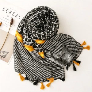 Detail of printed scarf featuring leopard patterns, stripes, and yellow tassel accents