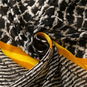 Macro shot of leopard print and yellow geometric color blocks on a soft long scarf