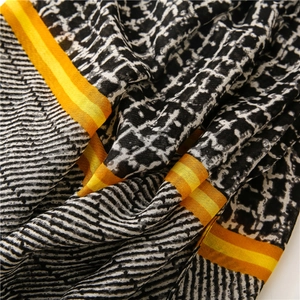 Detail of soft weave texture with black white geometric grid and vibrant orange border