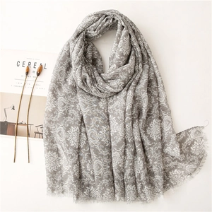Macro view of grey floral pattern scarf with soft tassels and elegant cotton-linen texture