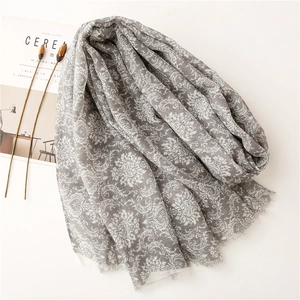 Detail of gray vintage floral scarf with delicate fringe edges and soft linen texture