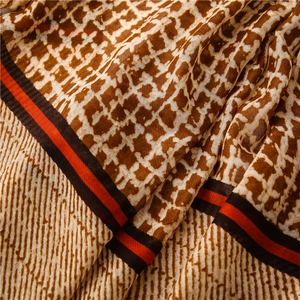 Detail of vintage geometric plaid scarf showing rich fabric texture and striped border