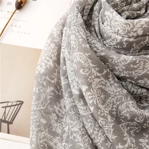 Detailed close-up of paisley floral pattern on a grey and white linen-feel shawl scarf