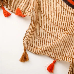 Detail of vintage geometric scarf with wave patterns and colorful fringe tassels