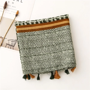 Detail of retro geometric scarf with tassels in olive green, camel, and beige