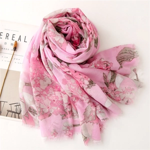 Detail of pink floral scarf with frayed edges next to a lifestyle magazine