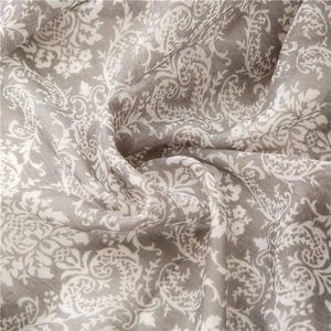 Detail of soft grey and white paisley floral pattern fabric with fine textile texture