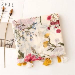 Detailed view of floral cotton scarf featuring tassels and subtle silver stripe texture