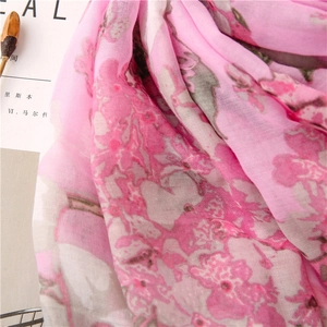 Close-up of pink floral print scarf with lightweight breathable fabric texture and drape