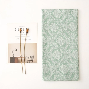 Flat lay of light green floral scarf with damascus patterns and magazine prop