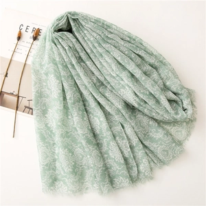 Macro view of mint green paisley scarf with soft fringe details and lightweight fabric